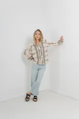 Camisa beige con estampado boho en negro, corte relajado, mangas largas con puño elástico y botones frontales.