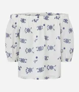 Blusa de hombros descubiertos color crema con estampado floral azul, mangas cortas abullonadas y detalle de hilo metalizado.