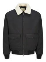 Campera bomber negra de Jack & Jones Premium, con cuello de béisbol y cierre de cremallera. Tiene bolsillos frontales y puños ribeteados. El cuello es de piel sintética color crema.