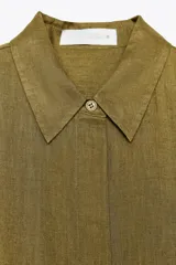 Camisa marrón de lino con cuello solapa y manga larga terminada en puño. Cierre frontal con botones.