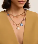 Collar de capas dorado con eslabones orgánicos con efecto martillado, esferas y colgantes místicos.