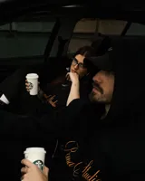 Hoodie color beige con capucha, cordones ajustables y bolsillo tipo canguro. Estampa bordada en el frente con la leyenda "Poona Studio".