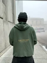 Hoodie verde militar de felpa con frisa gruesa, corte boxy, estampado dorado en la espalda con la frase "BURN THE SHIPS" y terminaciones de calidad superior.
