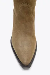 Bota alta color marrón de serraje, con puntera terminada en punta y taco cuadrado.
