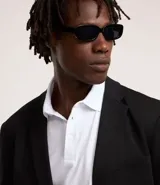 Polo blanca de corte regular, con cuello inglés, tapeta con botones y detalles texturizados.