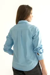 Camisa celeste de corte clásico con bolsillo en el pecho y botones al tono.