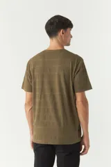 Remera color verde militar con textura a rayas horizontales, cuello redondo y logo bordado en el pecho. Corte clásico.
