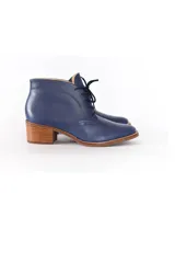 Botines de cuero azul con cordones frontales y tacón bloque de madera clara de 6 cm.