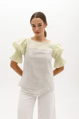 Blusa de mangas cortas abullonadas color verde claro, con escote cuadrado y cuerpo a rayas horizontales grises y blancas.