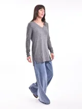 Saco gris melange de tejido de punto con cuello en V y mangas largas con botones decorativos en los puños.