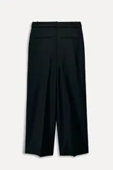 Pantalón negro de tiro alto confeccionado en mezcla de lana, con trabillas en la cintura, bolsillos laterales y falsos bolsillos de vivo en la espalda. Incluye cinturón de lazo en el mismo tejido y cierre frontal con cremallera, botón interior y ganchos metálicos.
