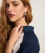 Remera de encaje blanco con mangas cortas raglán azul marino, cuello en V y estampado frontal con la inscripción "Kansas League Est. 1995".