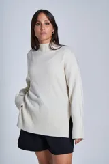 Sweater color crema de media polera, de tejido de punto con detalles acanalados en puños, bajo y cuello.