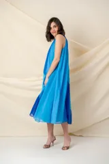 Vestido midi de crepe de seda en tonos de azul y celeste, de corte suelto y cuello halter con cadena.