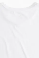 Remera deportiva blanca de corte boxy, confeccionada en tejido funcional DryMove™ que ayuda a absorber el sudor. Tiene cuello redondo, mangas cortas con hombros caídos y bajo recto.