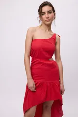 Vestido largo rojo de algodón y lino, con un hombro descubierto, bretel fino con lazo, recorte en la cintura y falda asimétrica con volados.