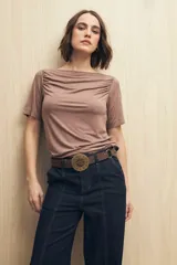 Remera blanca de cuello bote con frunces en los hombros y mangas cortas.