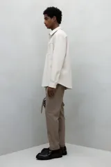 Pantalón jogger de vestir color beige, corte slim fit, con cintura elástica ajustable con cordón, pliegues delanteros y traseros, bolsillos laterales al bies y bolsillos traseros insertados.