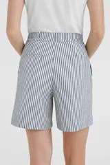 Short de lino de tiro alto, corte ancho y largo hasta la mitad del muslo, con estampado de rayas verticales blancas y azul oscuro.