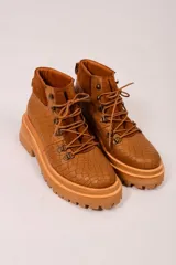 Borcegos marrones de cuero con textura símil cocodrilo, caña media con detalle de gamuza en la parte superior, cordones marrones y suela track.
