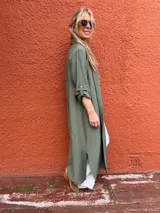 Sobrecamisa larga verde militar de viscosa con cuello camisero, cierre frontal con botones y mangas largas con puños abotonados. Presenta tajos laterales.
