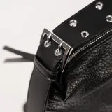 Cartera negra de cuero con textura granulada, forma rectangular y cierre superior con cremallera. Tiene una correa de hombro ajustable con apliques metálicos y detalles de cordones en los laterales.