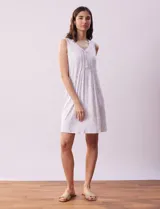 Camisón corto negro con estampado de lunares blancos, escote en V con botones y detalle plisado en el pecho.