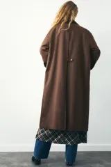 Trench color verde oscuro con cuello solapa combinado en pana marrón y manga larga. Detalle de acabados con trabillas y pinza en espalda. Bolsillos delanteros con solapa y botón a presión. Tejido encerado efecto lavado. Cierre frontal con botones a presión.