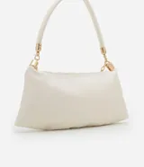 Cartera shoulder de poliuretano color crema, con asa corta de mano y asa larga de cadena dorada, ambas removibles. Incluye cierre de cremallera y borla decorativa.