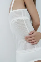 Top blanco de punto con tirantes finos y escote redondo.