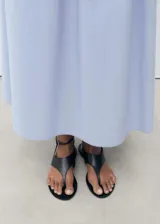 Falda larga color celeste claro, de tejido de algodón, con cintura elástica ajustable mediante cordón y bolsillos laterales.