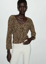 Blusa de tejido fluido con estampado animal print, cuello pico y manga larga.