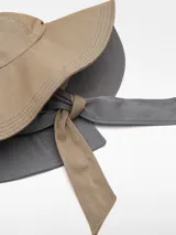 Sombrero de ala ancha bicolor con rayas verticales, confeccionado en poliéster y algodón. Presenta tiras anchas para atar con logo bordado.