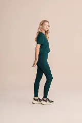 Calza larga de lycra color verde oscuro, de alta compresión, con bolsillos laterales.