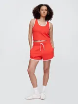 Short blanco con ribete verde, cintura elastizada con cordón ajustable y corte holgado.