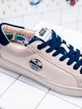 Zapatillas bajas de cuero color crema con detalles en azul marino y suela blanca. Presentan el logo de Star Wars en la lengüeta y el dibujo de R2-D2 en el lateral.