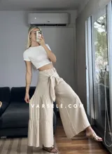 Pantalón palazzo color beige con lazo en la cintura.