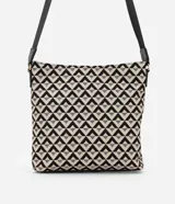 Bolso bandolera mediano de poliuretano con estampado de triángulos en blanco y negro. Tiene correa ajustable, cierre de cremallera, bolsillo frontal con cremallera y bolsillo interior.