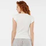 Camiseta blanca de punto con cuello redondo y mangas cortas con volantes.
