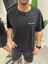 Remera negra de algodón con efecto lavado, corte oversize y cuello redondo. Presenta un pequeño texto blanco en el pecho que dice "BOHEMIANDESIGN®".