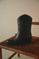Bota texana negra de cuero con bordados y terminación en punta.