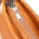 Bandolera chica de cuero color habano, con acceso por cierre y correa larga regulable.