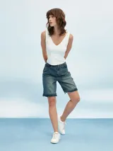 Pantalón de jean azul de corte ancho con aberturas a la altura de las rodillas.