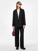 Blazer negro de corte oversize con solapas de muesca, cierre con dos botones y bolsillos delanteros con solapa. Decorado con pequeños cristales plateados.