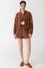 Bomber color coral confeccionada en mezcla de algodón y lino, con cierre frontal y puños elásticos. Presenta un bordado grande en la espalda inspirado en la colección La Verdulería.