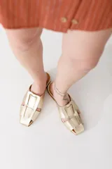 Zuecos plateados de cuero con diseño tejido y punta cuadrada.