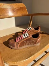 Championes urbanos de cuero color blanco hueso con detalles en marrón. Presentan cordones de algodón color crudo y logo bordado en el lateral.