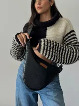 Bandolera negra de cuero con textura croco, correa ajustable y logo de la marca en etiqueta de cuero.