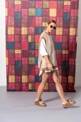 Chaleco de punto color beige con rayas verticales marrones y cuello redondo.