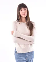 Buzo de tejido de punto color beige claro, con cuello redondo y manga larga. Presenta botones decorativos en los puños.